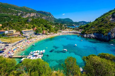 Agios Spiridon Plajı kristal berrak gök mavisi suyu ve güzel manzara manzaralı beyaz plajı - Paleokastritsa, İyon takımadası, Yunanistan 'daki Korfu adasının cennet kıyısı.