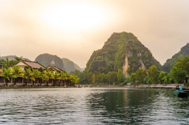 Tam Coc Ulusal Parkı - Ninh Binh Eyaleti 'ndeki Ngo Dong Nehri boyunca seyahat eden turistler Trang Bir peyzaj kompleksi, Vietnam - Karst kuleleri ve pirinç tarlalarının oluşturduğu manzara