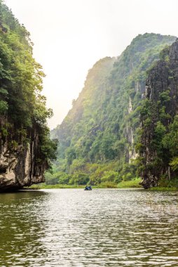 Tam Coc Ulusal Parkı - Ninh Binh Eyaleti 'ndeki Ngo Dong Nehri boyunca seyahat eden turistler Trang Bir peyzaj kompleksi, Vietnam - Karst kuleleri ve pirinç tarlalarının oluşturduğu manzara
