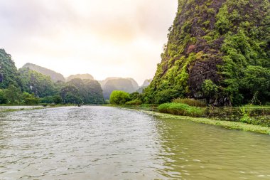 Tam Coc Ulusal Parkı - Ninh Binh Eyaleti 'ndeki Ngo Dong Nehri boyunca seyahat eden turistler Trang Bir peyzaj kompleksi, Vietnam - Karst kuleleri ve pirinç tarlalarının oluşturduğu manzara