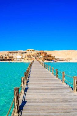 Orange Bay Sahili 'ndeki ahşap iskele, kristal berrak gök mavisi suyu ve beyaz plajla - Giftun adasının cennet kıyısı, Mahmya, Hurghada, Kızıldeniz, Mısır.