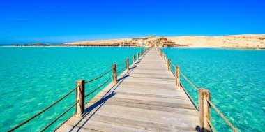 Orange Bay Sahili 'ndeki ahşap iskele, kristal berrak gök mavisi suyu ve beyaz plajla - Giftun adasının cennet kıyısı, Mahmya, Hurghada, Kızıldeniz, Mısır.
