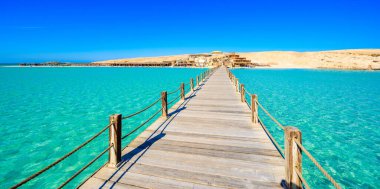 Wooden Pier at Orange Bay Beach with crystal clear azure water and white beach - paradise coastline of Giftun island, Mahmya, Hurghada, Red Sea, Egypt. clipart