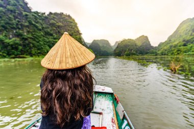 Tam Coc Natioanl Parkı - Ninh Binh Eyaleti 'ndeki Ngo Dong Nehri boyunca seyahat eden Vietnamlı kız, Trang An manzara kompleksi, karst kuleleri ve pirinç tarlaları tarafından oluşturulan manzara - Vietnam