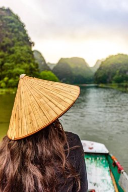 Tam Coc Natioanl Parkı - Ninh Binh Eyaleti 'ndeki Ngo Dong Nehri boyunca seyahat eden Vietnamlı kız, Trang An manzara kompleksi, karst kuleleri ve pirinç tarlaları tarafından oluşturulan manzara - Vietnam