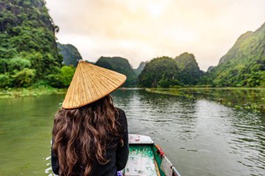 Tam Coc Natioanl Parkı - Ninh Binh Eyaleti 'ndeki Ngo Dong Nehri boyunca seyahat eden Vietnamlı kız, Trang An manzara kompleksi, karst kuleleri ve pirinç tarlaları tarafından oluşturulan manzara - Vietnam