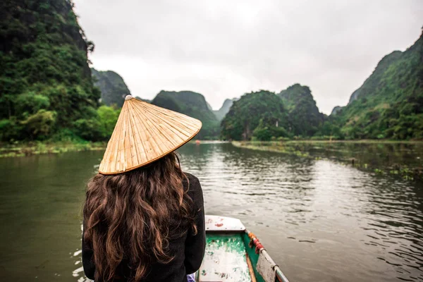 Tam Coc Natioanl Park - Vietnamese Girl traveling in boat along the Ngo Dong River at Ninh Binh Province, Trang An landscape complex, Landscape formed by karst towers and rice fields - Vietnam