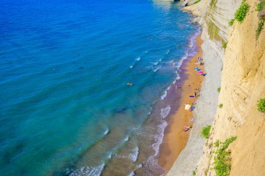 Peroulades 'teki Loggas plajı, Korfu' da, İyon adası, Yunanistan ve Avrupa 'nın yakınlarındaki yüksek kayalık beyaz kayalık ve kristal berrak gök mavisi suyu olan bir cennet kumsalı.