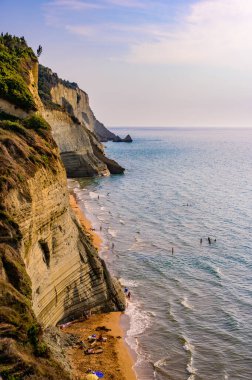 Peroulades 'teki Loggas plajı, Korfu' da, İyon adası, Yunanistan ve Avrupa 'nın yakınlarındaki yüksek kayalık beyaz kayalık ve kristal berrak gök mavisi suyu olan bir cennet kumsalı.