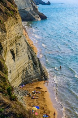 Peroulades 'teki Loggas plajı, Korfu' da, İyon adası, Yunanistan ve Avrupa 'nın yakınlarındaki yüksek kayalık beyaz kayalık ve kristal berrak gök mavisi suyu olan bir cennet kumsalı.
