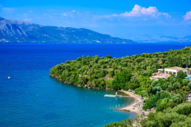 Kommeno 'daki Spilios plajı Kerkyra' ya yakın, Korfu, İyon adası, Yunanistan ve Avrupa 'da kristal berrak gök mavisi suyu bulunan bir cennet plajı.