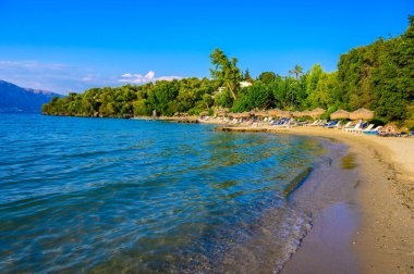 Kommeno 'daki Spilios plajı Kerkyra' ya yakın, Korfu, İyon adası, Yunanistan ve Avrupa 'da kristal berrak gök mavisi suyu bulunan bir cennet plajı.