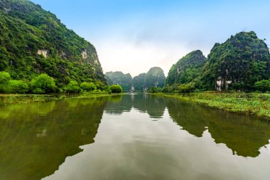 Tam Coc Natioanl Parkı - Ninh Binh Eyaleti 'ndeki Ngo Dong Nehri boyunca seyahat eden Vietnamlı kız, Trang An manzara kompleksi, karst kuleleri ve pirinç tarlaları tarafından oluşturulan manzara - Vietnam