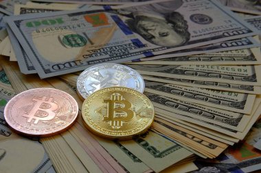 Dolar banknotu arka planına sahip Bitcoin.