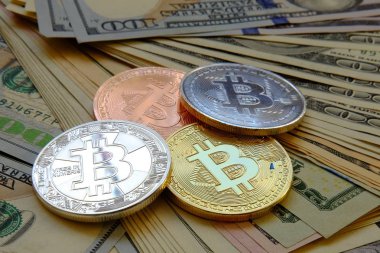 Dolar banknotu arka planına sahip Bitcoin.