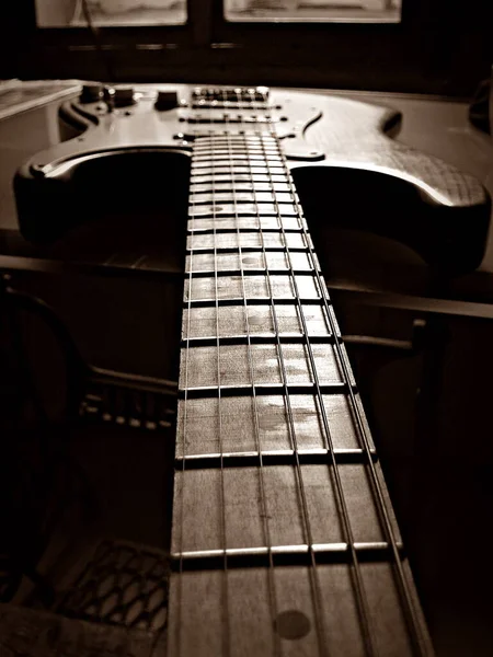 セピアのテーブルの上に隔離されたギター — ストック写真