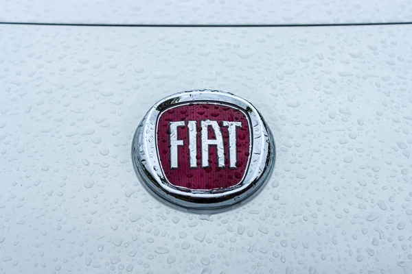 Emblema de um carro Fiat em gotas de chuva . — Fotografia de Stock