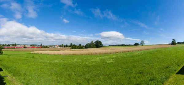 Vista panorámica del campo de centeno en el suburbio de Neustadt (distrito de Marburg-Biedenkopf en Hessen). En el tranvía de fondo de Bahn Regional por Deutsche Bahn . — Foto de Stock