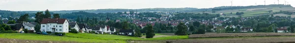 Panoramisch uitzicht over de kleine stad Neustadt (district Marburg-Biedenkopf in Hessen), de buitenwijken en de omliggende landbouwgrond. — Stockfoto