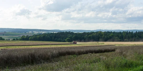 Skörden på fälten i förorterna till den lilla staden av Neustadt (Marburg-Biedenkopf distrikt i Hessen). Skördare på fältet. — Stockfoto
