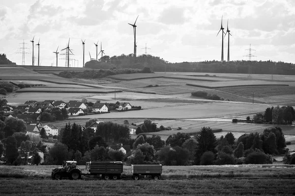 Utsikt over den lille byen Neustadt, en forstad og omliggende jordbruksland og landbruksmaskiner. Svart og hvit . – stockfoto