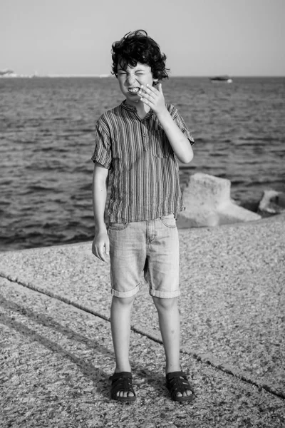 Un băiat nemulțumit stă lângă mare . — Fotografie, imagine de stoc