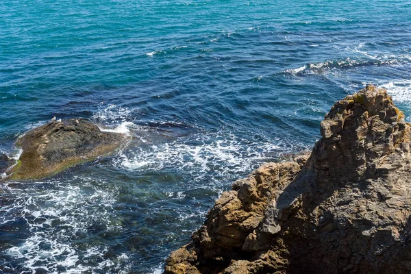 Mavi deniz, dalgalar ve kayalık sahil. — Stok fotoğraf