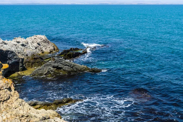Mavi deniz, dalgalar ve kayalık sahil. — Stok fotoğraf