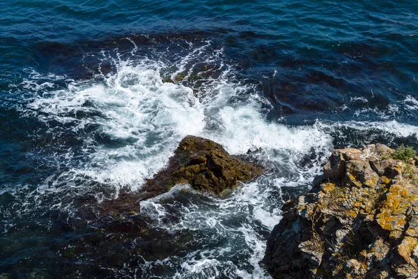Mar azul, ondas e costa rochosa . — Fotografia de Stock