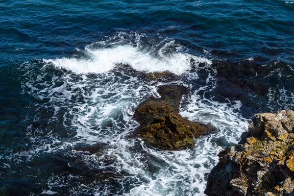 Mar azul, ondas e costa rochosa . — Fotografia de Stock