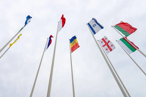 Flags of various European countries against the background of the cloudy sky. — Stock Photo, Image