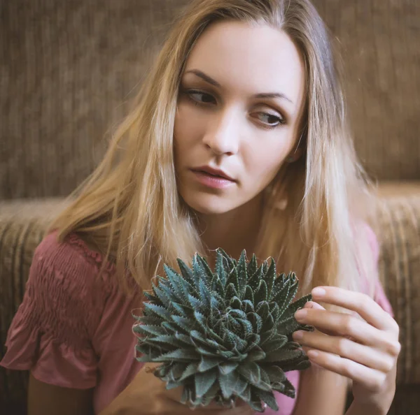 Woman holding a green cactus. — Stock Photo, Image
