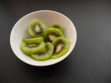 Beyaz bir tabak içinde kivi dilimleri.