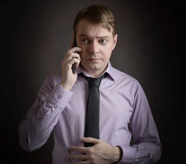 Homem de camisa rosa falando ao telefone . — Fotografia de Stock