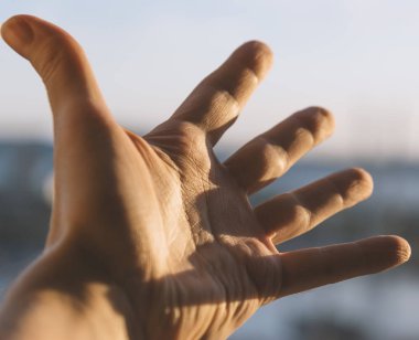 Gökyüzüne uzanan bir adamın eli. 