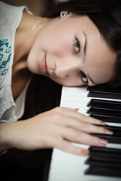 Girl and piano keyboard. — Stock Photo, Image