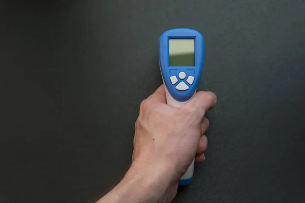 Handen håller en beröringsfri Ir kropp termometer. — Stockfoto
