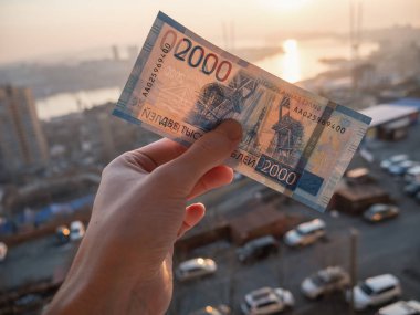 Yeni Rus 2000 ruble şehir arka plan üzerinde elinde.