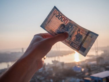 Yeni Rus 2000 ruble şehir arka plan üzerinde elinde.