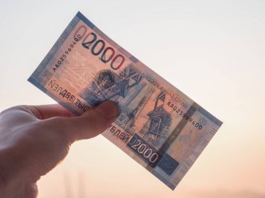 Yeni Rus 2000 ruble şehir arka plan üzerinde elinde.
