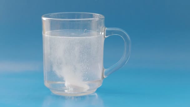 Brausetablette Die Ein Glas Wasser Auf Blauem Hintergrund Fällt — Stockvideo
