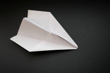 Koyu arka plan üzerinde kağıt uçak. Seçici odak.