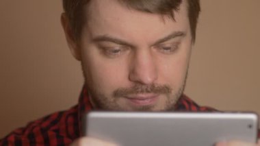 Genç adam bir tablet vasıl - sürpriz duygu arıyor.