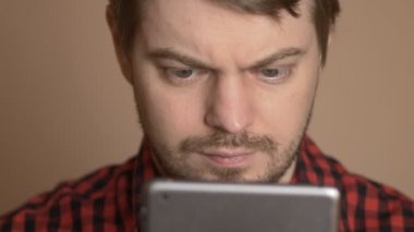 Genç adam evde tablet bilgisayar dokunmatik ekran kullanma.