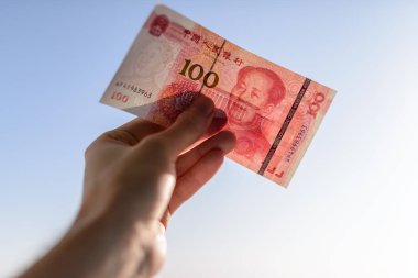 Elinde 100 yuan. Seçici odak ve sığ derinlik-in tarla.
