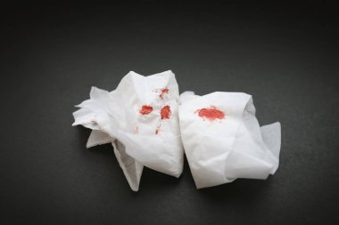 Karanlık bir arka plan üzerinde kan olan beyaz peçete.