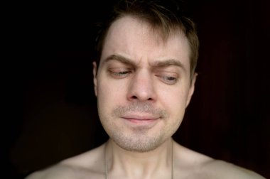 Karanlık arka planda kızgın genç bir adamın portresi..