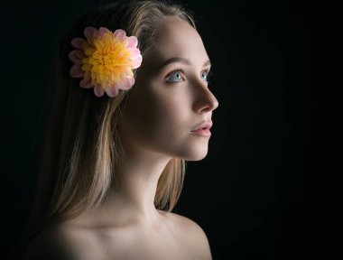 Saçında çiçekler olan genç bir kadının portresi..