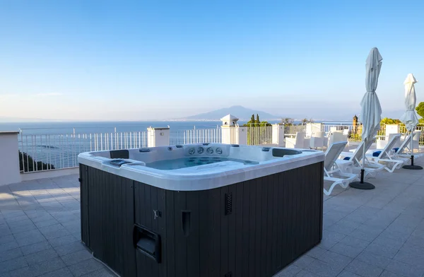 Bubbelbad i en Resort takterrass med utsikt över Medelhavet och vulkanen Vesuvius, Sorrento, Italien — Stockfoto