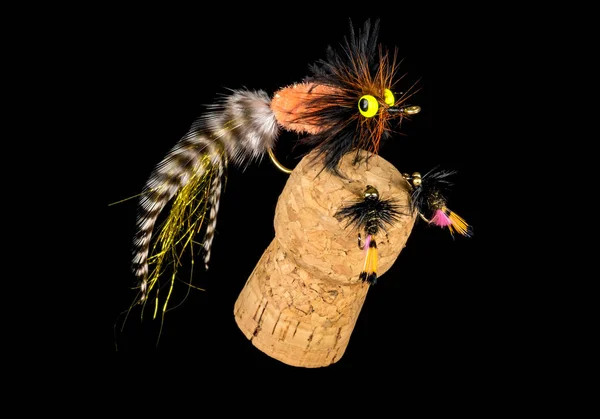 Moscas de pesca coloridas amarradas à mão exibidas na cortiça de champanhe — Fotografia de Stock